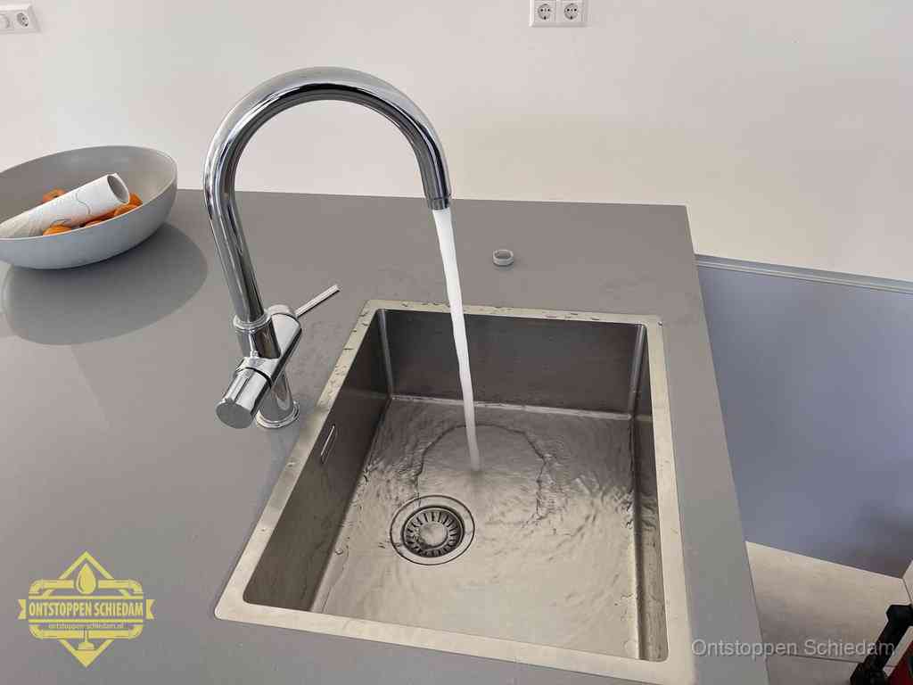 Een vrij doorstromende rvs spoelbak waar het water moeiteloos wegloopt, het resultaat van slim onderhoud dat geld bespaart in Schiedam