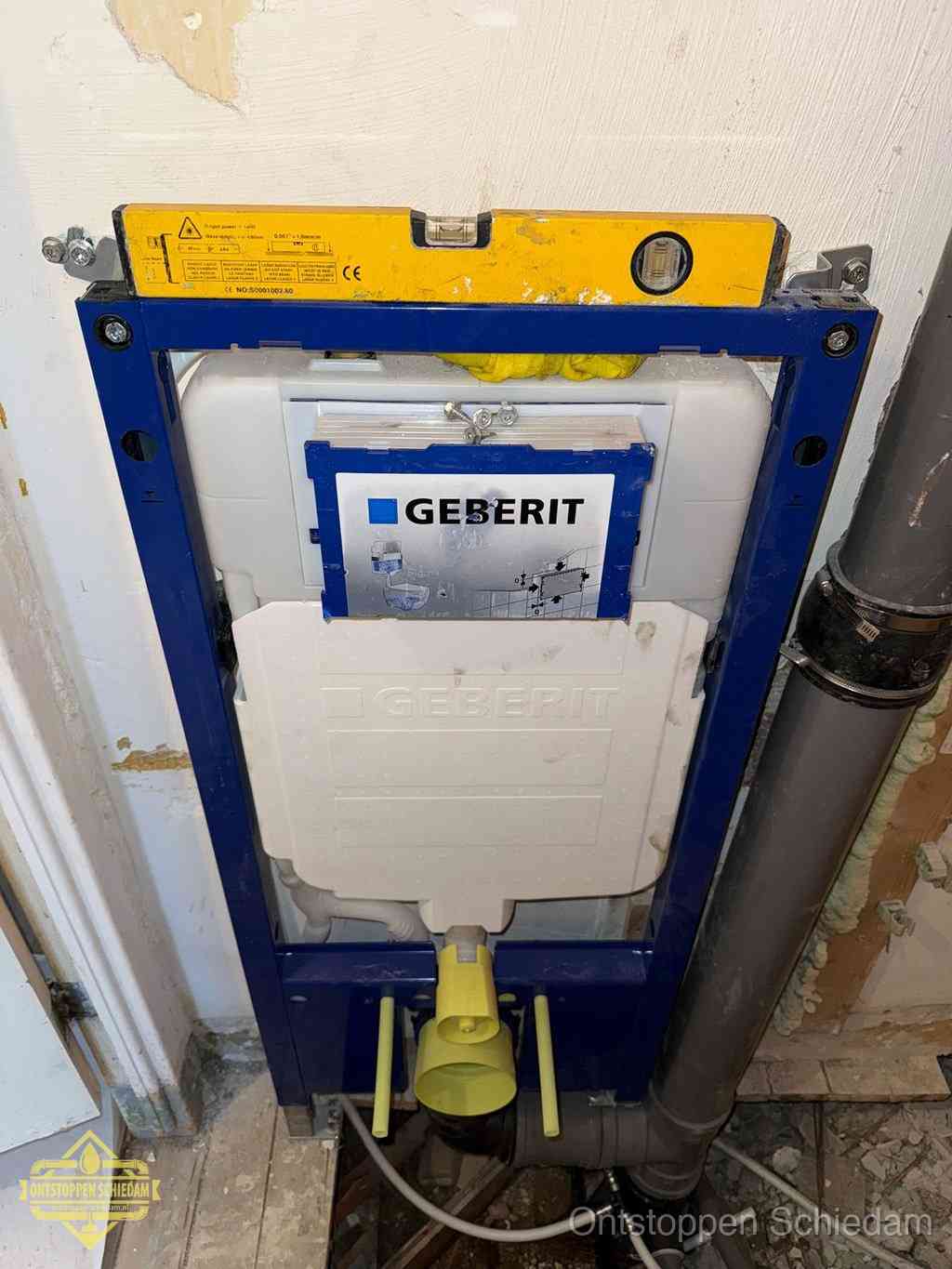 Een Geberit inbouwreservoir met frame voor een hangtoilet tegen de wand, met de afvoerbocht naar de vloer, kenmerkend voor een verstopt hangtoilet in Schiedam