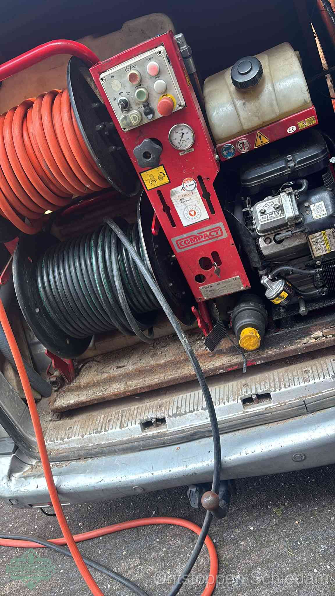Een rood hogedruk-rioolreinigingstoestel in de laadbak van de bedrijfsbus, apparatuur voor een hardnekkige afvoerverstopping in Schiedam