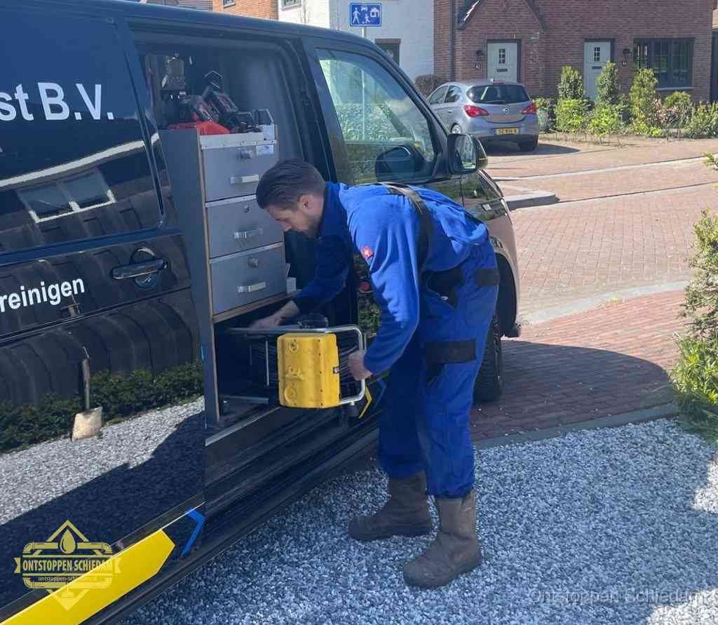 Een monteur pakt apparatuur uit de bedrijfsbus voor service aan huis, het moment om een professional in te schakelen in Schiedam